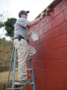 Dr. Joey Mehlhorn paints one of the houses the group worked on throughout the week. (Mary Jean Hall)