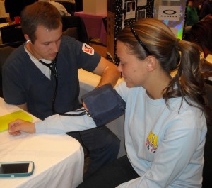 Kristen Mitchell sits patiently as a nursing student takes her blood pressure. (Becca Partridge)